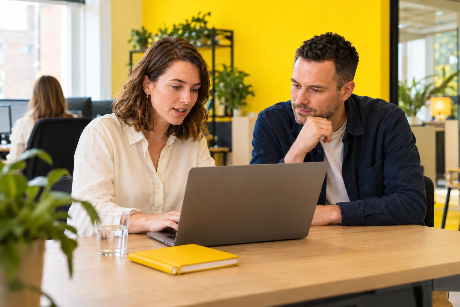 Twee collega’s bespreken een klantvraag bij een laptop
