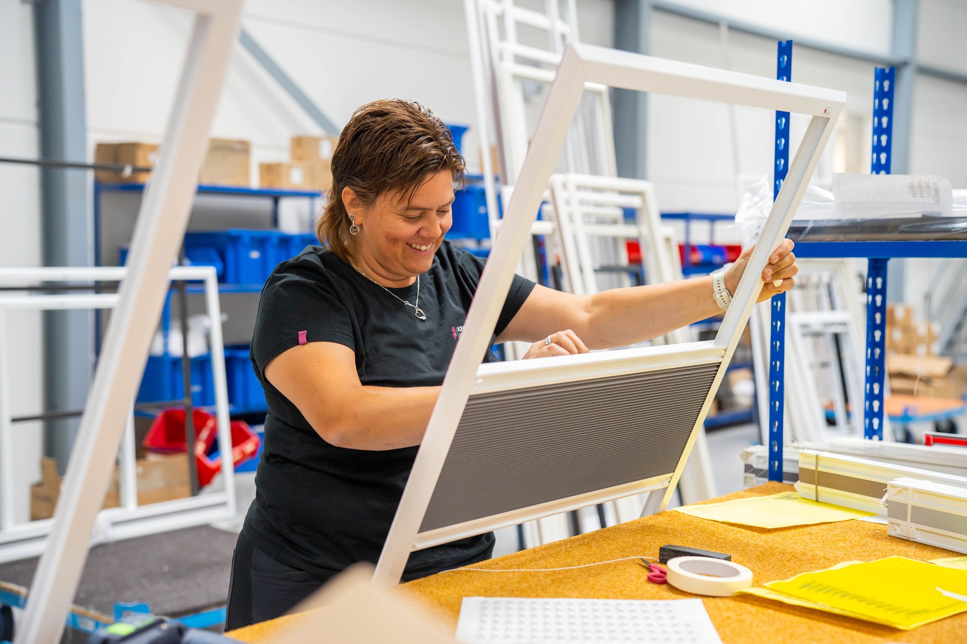 Een medewerker maakt raamdecoratie in de eigen productie van Keje